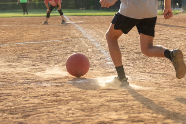 adult man playing kickball in a public park league
